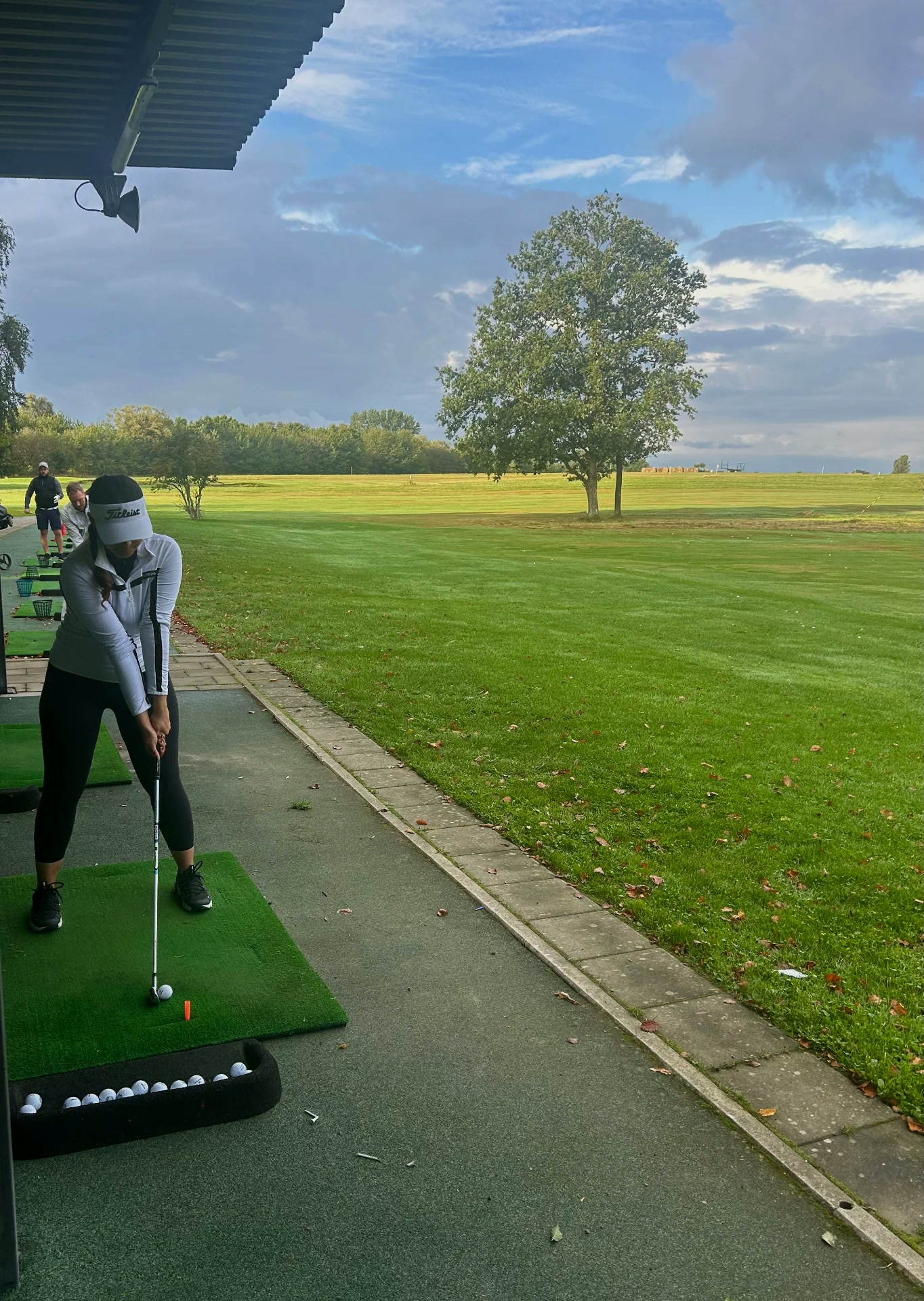 Agrima at the driving range mid swing on an autumn morning